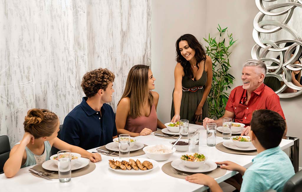 Family gathered around a dining room table set for dinner at Spectrum Resort Orlando